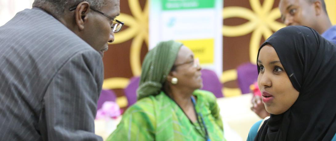 Somali woman talking with a man at a conference